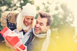 A picture of a young couple with a present in the park